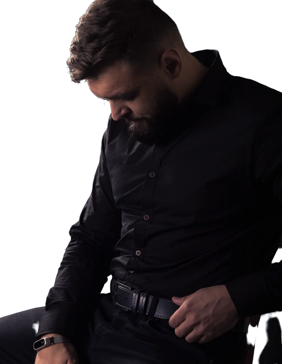 Homem de camisa preta, sentado, em fotografia editorial (imagem ilustrativa)